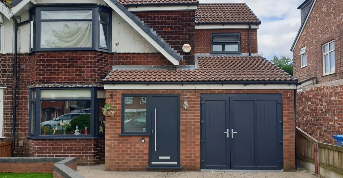 Brick house with anthracite grey bay windows and a matching entrance door
